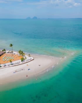 Drone aerial view at Koh Muk a tropical island with palm trees and soft white sand, and a turqouse colored ocean in Koh Mook Trang Thailand