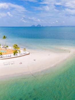 Top view at Koh Muk a tropical island with palm trees and soft white sand, and a turqouse colored ocean, sandbar in the ocean in Koh Mook Trang Thailand