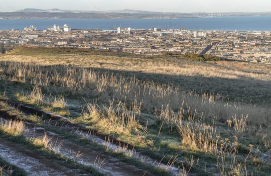 Edinburgh, Scotland - Jan 17, 2024 - Amazing Edinburgh cityscape and Leith docks with the skyline seen from the top of Salisbury Crags. Destinations in Europe, Space for text, Selective focus.