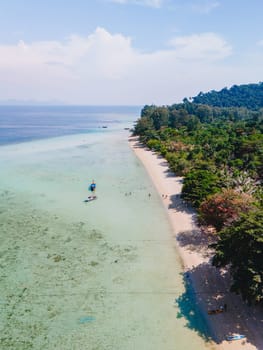 Drone aerial view at Koh Kradan a tropical island with palm trees soft white sand, and a turqouse colored ocean in Koh Kradan Trang Thailand