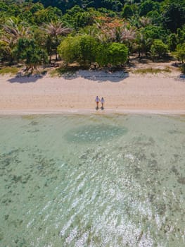 Drone aerial view at Koh Kradan a tropical island with palm trees soft white sand, and a turqouse colored ocean in Koh Kradan Trang Thailand