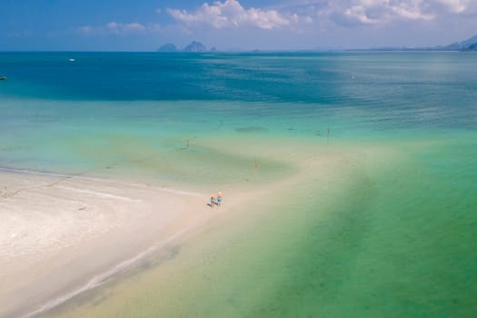 Drone aerial view at Koh Muk a tropical island with palm trees and soft white sand, and a turqouse colored ocean in Koh Mook Trang Thailand