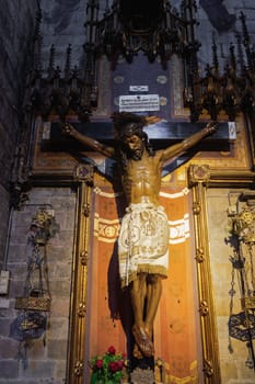 Jesus on the cross statue inside christian church Basilica of the Immaculate Conception and Assumption of Our Lady - Basilica de la Purissima Concepcio - in Barcelona, Catalonia Spain.