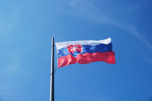 The flag of Slovakia hangs on the mast, the colors are white, red and blue