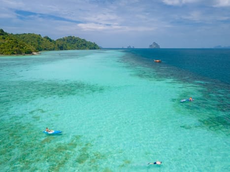 Young men in a kayak at the bleu turqouse colored ocean of Koh Kradan a tropical island with a coral reef in the ocean, Koh Kradan Trang Thailand