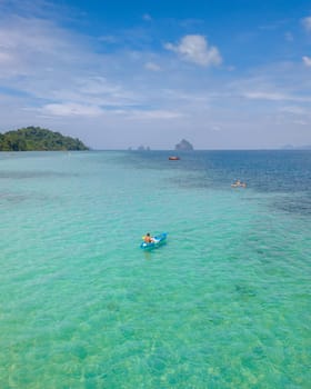 Young men in a kayak at the bleu turqouse colored ocean of Koh Kradan a tropical island with a coral reef in the ocean, Koh Kradan Trang Thailand