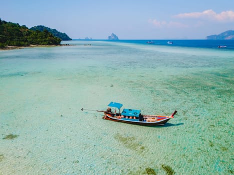 longtail boat in the turqouse colored ocean with clear water at Koh Kradan a tropical island in Trang Thailand