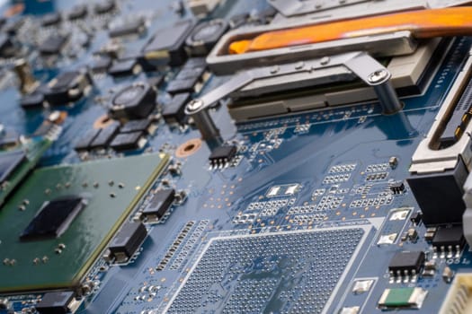 Concept laptop technology. A detailed shot of a computer motherboard, featuring a CPU, chipsets and circuit board showcasing the intricate engineering and composite materials used in its manufacturing. Selective focus