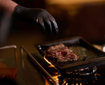 Close-up shot, a professional chef expertly prepares a delicious steak using modern cooking techniques, showcasing culinary excellence and precision in the art of gourmet cuisine.