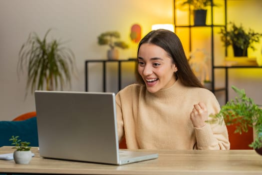 Surprised Caucasian woman using laptop computer, receive mail good news message shocked by sudden victory celebrate lottery jackpot win purchases online shopping play game at home apartment at table
