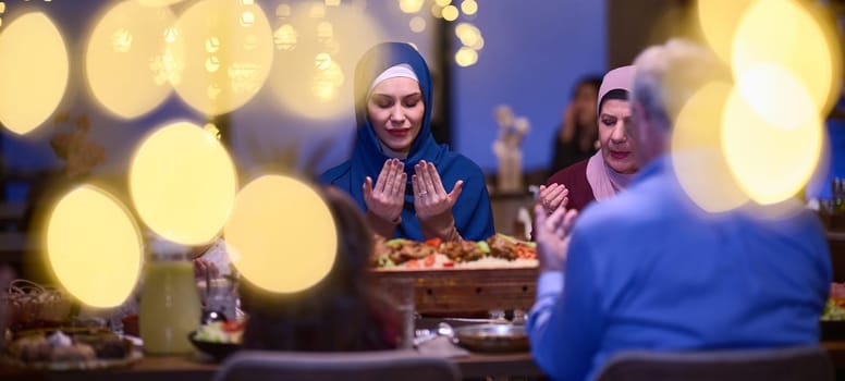 In a modern restaurant setting, a European Islamic family comes together for iftar during Ramadan, engaging in prayer before the meal, uniting tradition and contemporary practices in a celebration of faith and family.