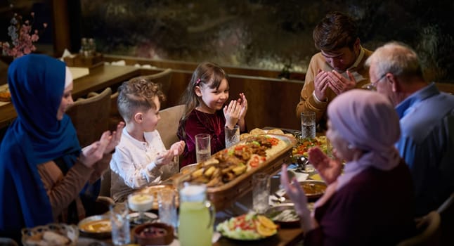 In a modern restaurant setting, a European Islamic family comes together for iftar during Ramadan, engaging in prayer before the meal, uniting tradition and contemporary practices in a celebration of faith and family.