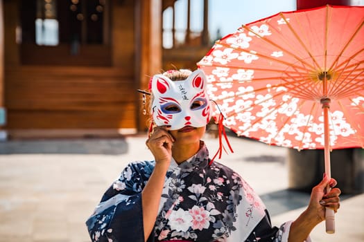 Asian girl in kimono and umbrella in Japanese theme park Hinoki Land in Chai Prakan District, Chiang Mai