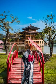 Asian girl in kimono and umbrella in Japanese theme park Hinoki Land in Chai Prakan District, Chiang Mai