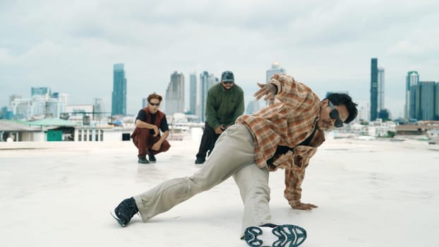 Professional hispanic break dancer practice B boy dance while multicultural friends at roof top. Young modern dancing group doing hip hop movement. Style,fashion,action. Outdoor sport 2024. Endeavor.