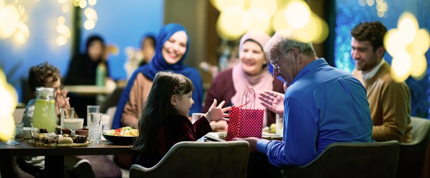 Grandparents arrive at their children's and grandchildren's gathering for iftar in a restaurant during the holy month of Ramadan, bearing gifts and sharing cherished moments of love, unity, and cultural exchange, as they eagerly await their meal together.