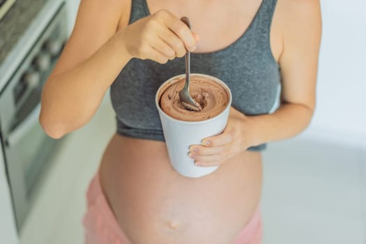 Happy pregnant young woman eating ice cream.