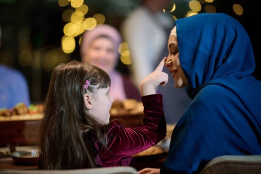 In a heartwarming scene, a happy European Islamic family and a young girl delightfully engage with her mother while eagerly anticipating their iftar meal, radiating joy, love, and familial bonding during the holy month of Ramadan