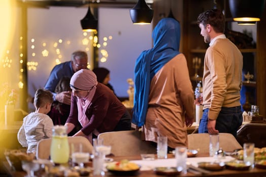 Grandparents arrive at their children's and grandchildren's gathering for iftar in a restaurant during the holy month of Ramadan, bearing gifts and sharing cherished moments of love, unity, and cultural exchange, as they eagerly await their meal together.