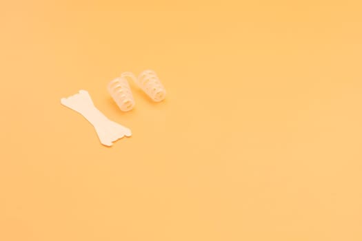 Mockup Anti Snoring Device. Nose Relief Nasal Dilator and White Nasal Strip on Peach Yellow Background, Sleeping Apnea Solution for Nasal Breathers, Snoring Problem. Space For Text Horizontal Plane
