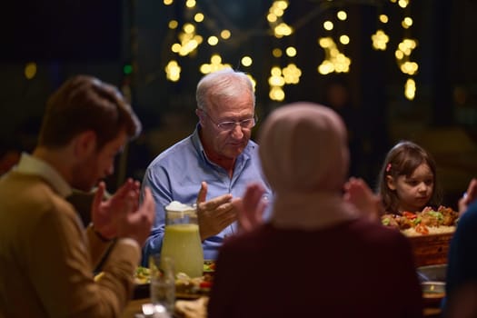 In a modern restaurant setting, a European Islamic family comes together for iftar during Ramadan, engaging in prayer before the meal, uniting tradition and contemporary practices in a celebration of faith and family.