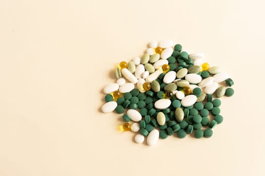 Mockup Assorted Pile of Colorful Pills, Green White Yellow, Beige Tablets, Capsules, Medical Supplement on Beige Background. Copy Space For Text. Pharmaceutical Concept. Horizontal Plane.