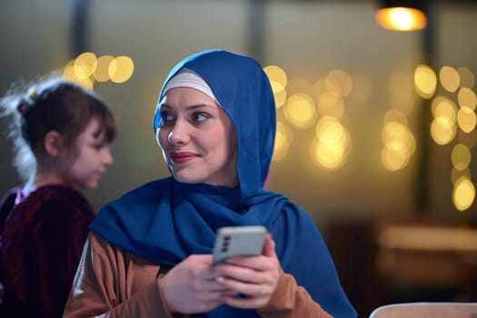 A beautiful European Muslim woman, adorned with a hijab, utilizes her smartphone to swiftly prepare for iftar during the sacred month of Ramadan, embodying the blend of tradition and modernity in her observance.