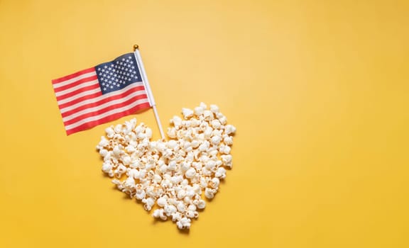National Popcorn Lover's Day. Top View Popcorn in Heart Shape with American USA Flag on Yellow Background. Copy Space. Greeting Card, Template No Text. Tasty salted Snack Flat Lay, Horizontal