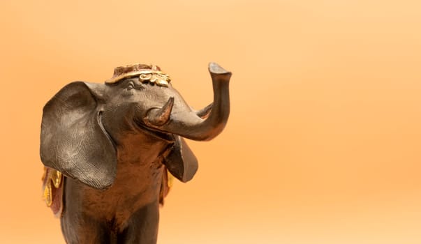 Mockup World Elephant Day. Bronze Decorated Elephant On Peach Yellow Background. Copy Space For Text. Ganesha Chaturthi Holiday. Sacred Symbol In Hindu, Buddhist Religions. Design, Horizontal Plane