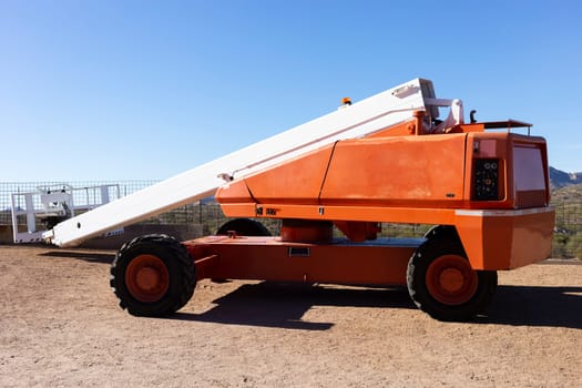 Telescopic Boom Lift For Construction, Painting, Electrical Work And Industrial Maintenance. Truck, Blue Sky On Background. Manlifting Cranes. Self Propelled Wheeled Hydraulic Articulated Boom Lift