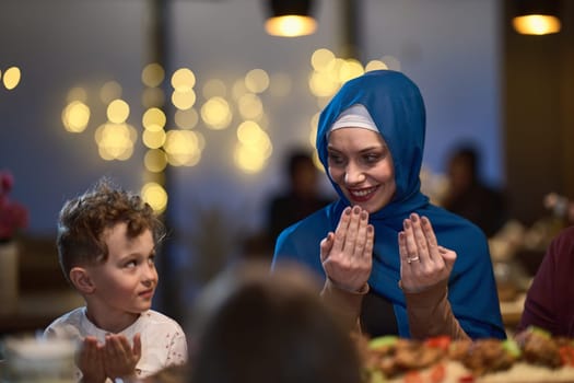 In a modern restaurant setting, a European Islamic family comes together for iftar during Ramadan, engaging in prayer before the meal, uniting tradition and contemporary practices in a celebration of faith and family.