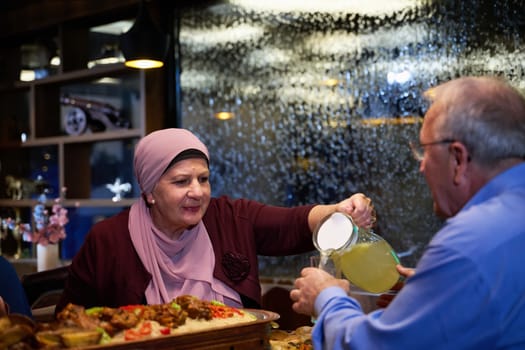 In a modern restaurant setting, an elderly Islamic European couple shares a meal for iftar during the holy month of Ramadan, epitomizing unity, companionship, and cultural tradition in their dining experience.