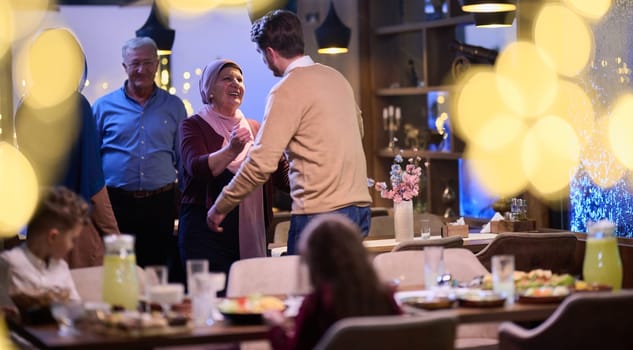 Grandparents arrive at their children's and grandchildren's gathering for iftar in a restaurant during the holy month of Ramadan, bearing gifts and sharing cherished moments of love, unity, and cultural exchange, as they eagerly await their meal together.