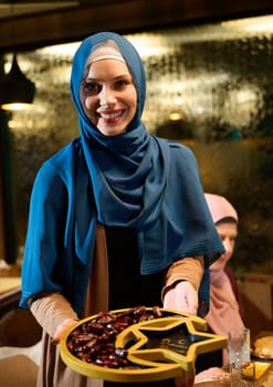 In a modern restaurant during the holy month of Ramadan, a woman in hijab lovingly serves her family fresh dates for iftar, embodying the spirit of generosity, familial bonding, and cultural tradition