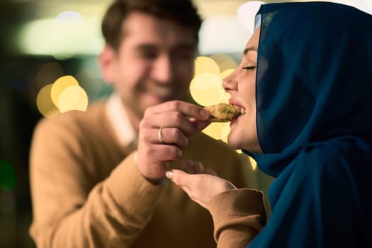 Islamic European couple shares laughter and enjoyment while savoring delicious pastries during iftar in the holy month of Ramadan, epitomizing joy, cultural celebration, and culinary delight.