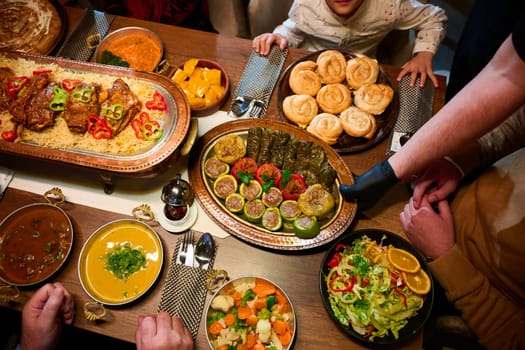 In this captivating aerial view, delicious food adorned with Ramadan decorations, including dates and meat, awaits the arrival of an European Islamic family, promising a festive and flavorful iftar celebration.