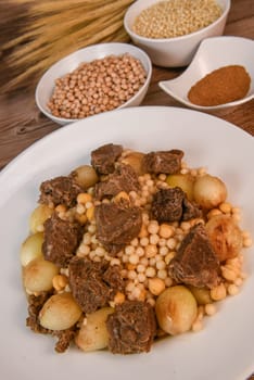 Moughrabieh is a popular dish in the Lebanese cuisine, LEBANESE RECIPE FOR MOUGHRABIEH WITH BEEF AND SMALL ONIONS, SEMOLINA PEARLS AND CHICKPEAS. High quality photo