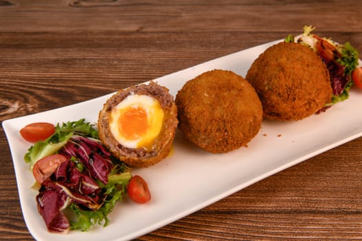 RECIPE FOR BREADED BEEF MEATBALLS STUFFED WITH A SOFT BOILED EGG. High quality photo