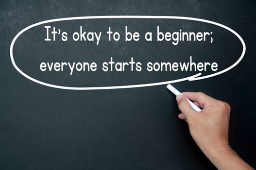 Hand writing It is okay to be a beginner affirmation on black board. Affirmation concept
