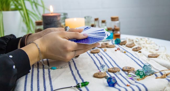 A fortune teller reads with tarot cards. Selective focus. Woman.