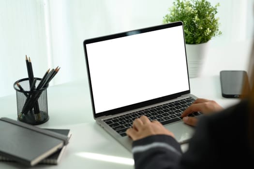 Young businesswoman working on laptop computer at desk. Business and technology concept.