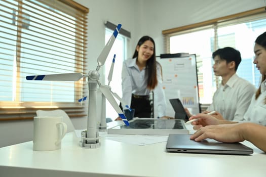 Select focus on a wind turbine model on a meeting table. Green energy development concept.