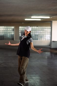 Full length of young woman dancing in parking garage. Hobby and active lifestyle concept.