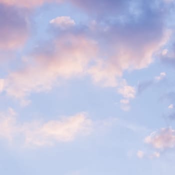 Background of blue sky with pale pink clouds at sunset