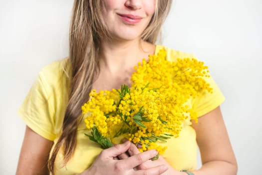 Beautiful young woman with mimosa flowers on white background. Close up