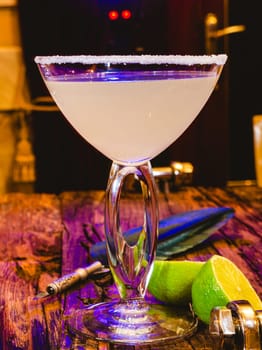 Margarita cocktail with lime in a glass on wooden table. Shallow dof.