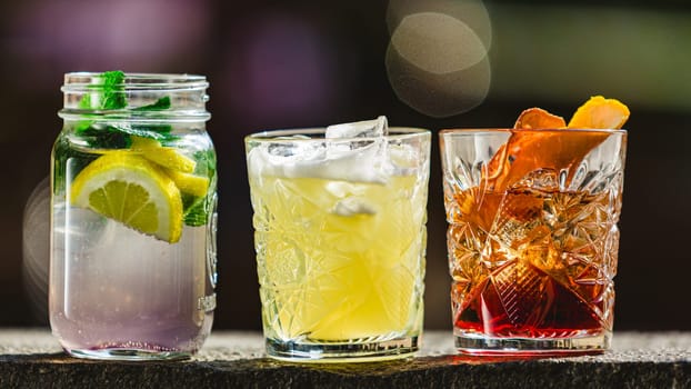 three different alcoholic cocktails with old-fashioned glasses.