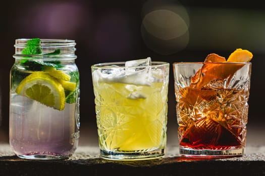 three different alcoholic cocktails with old-fashioned glasses.