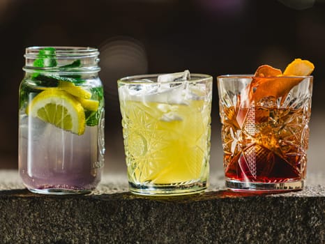 three different alcoholic cocktails with old-fashioned glasses.