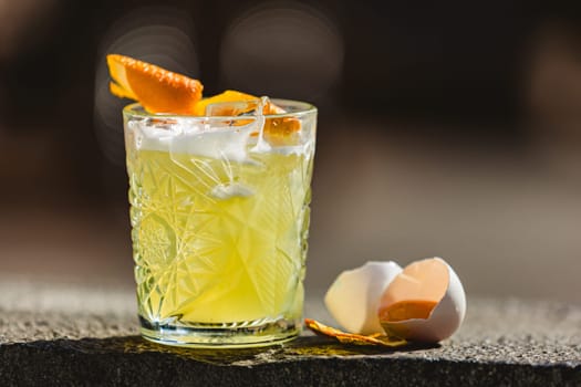 Closeup glass of whiskey sour cocktail decorated with lemon at bar background. Shallow dof